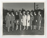 Nine women in gowns and hats on the field by Lonnie W. Fleming Sr.