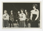 Three cheerleaders in front of a marching band by Lonnie W. Fleming Sr.