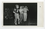 Football players and coaches standing on the sidelines by Lonnie W. Fleming Sr.