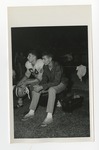A football player and a guy in normal clothes sitting on a bench during a game by Lonnie W. Fleming Sr.