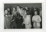 A group of girls surrounding a suited gentleman and smiling by Lonnie W. Fleming Sr.