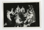 A group of cheerleaders sitting down and huddled together in a circle by Lonnie W. Fleming Sr.