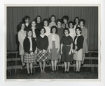 Three rows of young women taking a group photo in front of a curtain by Lonnie W. Fleming Sr.