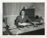 A suited gentleman at his desk by Lonnie W. Fleming Sr.