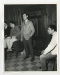 A gentleman standing in front of a wooden door with students sitting around him by Lonnie W. Fleming Sr.