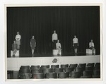 Seven women on stage practicing for a show by Lonnie W. Fleming Sr.