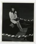 A girl in a white coat and black hat sitting on top of a car convertible by Lonnie W. Fleming Sr.