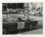 A girl in outerwear on top of a Ford Mustang convertible by Lonnie W. Fleming Sr.
