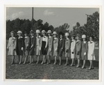 A row of girls in outerwear taking a group photo on a school green by Lonnie W. Fleming Sr.