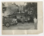 Firemen trying to stop a fire in a house by Lonnie W. Fleming Sr.